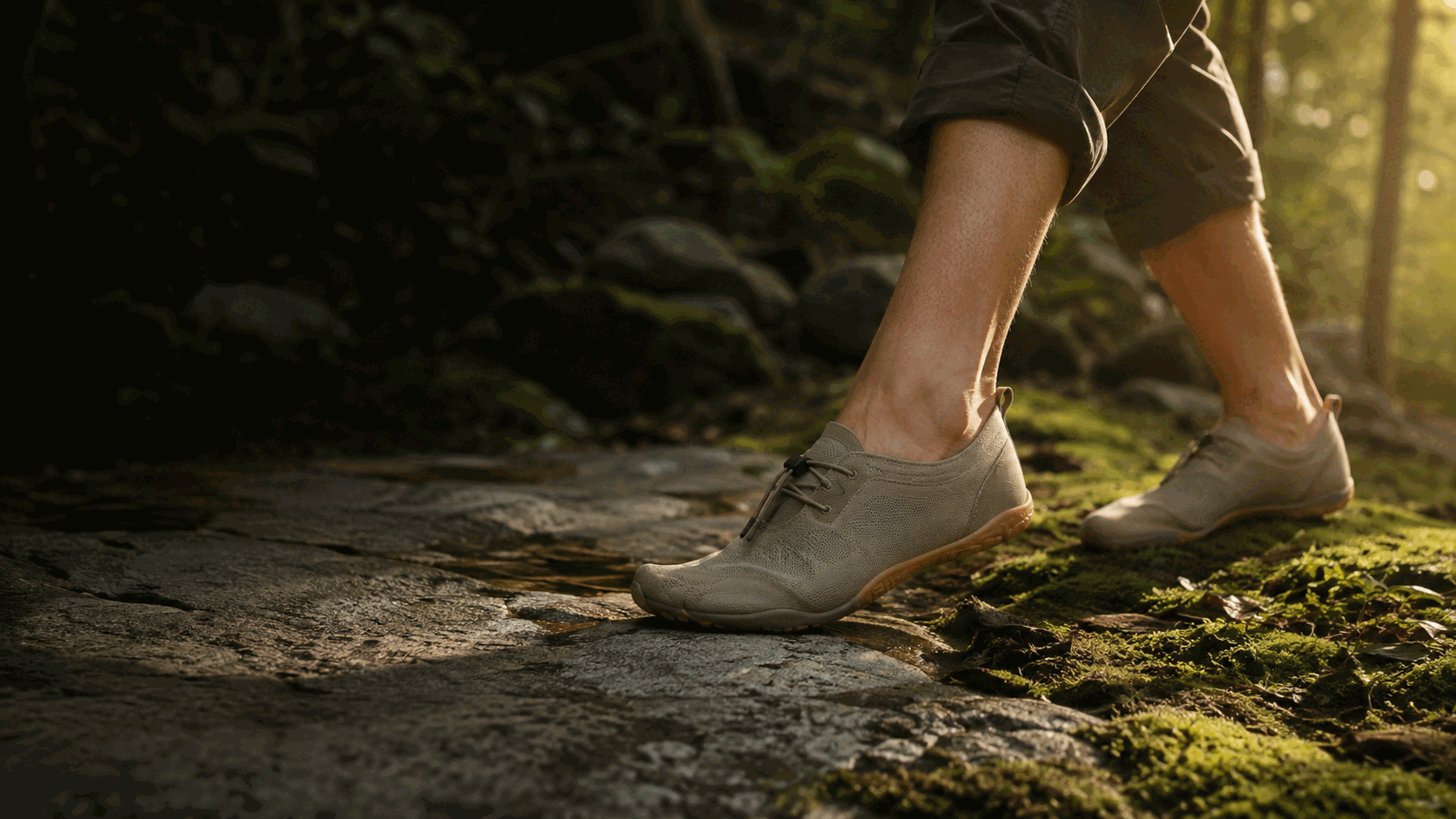 Walker wearing flexible, wide-toe minimalist shoes across stone and moss